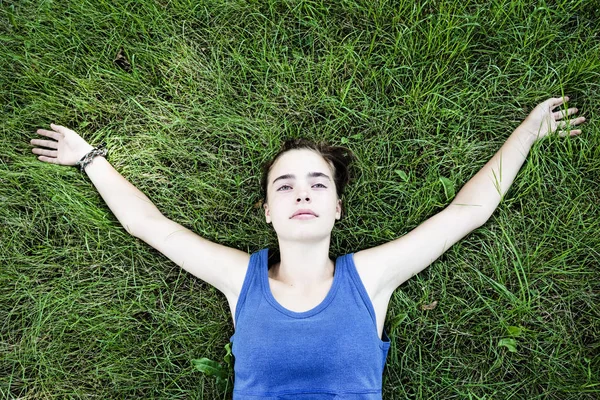 Porträt einer jungen Frau, die auf einer Wiese liegt — Stockfoto