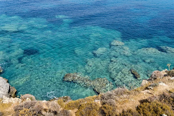 Overgrown cliff and turquoise ocean — Stock Photo, Image