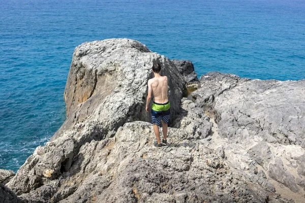 bir uçurumun üzerinde yürüyen genç adam