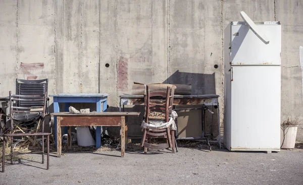 Muebles sucios viejos parados delante de una pared de hormigón Imagen De Stock