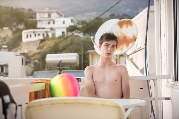 Jongeman zit op het terras van een hotel — Stockfoto