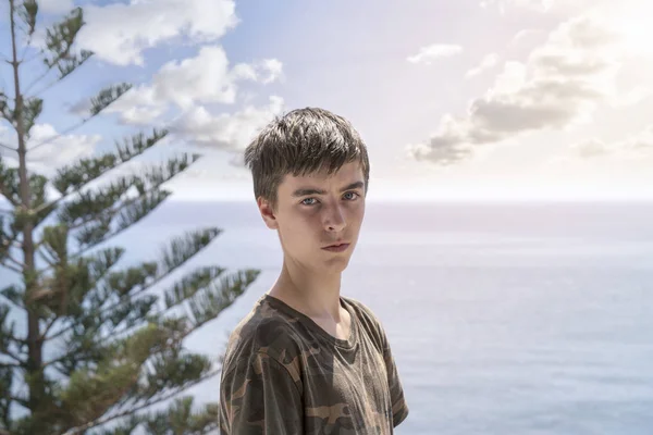Portret van een jonge man tegenover een oceaan landschap — Stockfoto