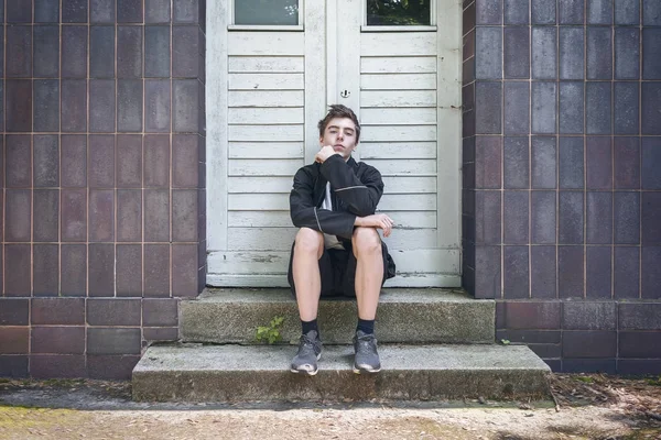 Portrait Jeune Homme Assis Devant Une Porte Dans Les Escaliers — Photo