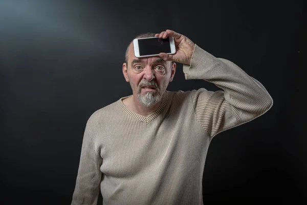 Viejo hombre no entiende su teléfono inteligente — Foto de Stock