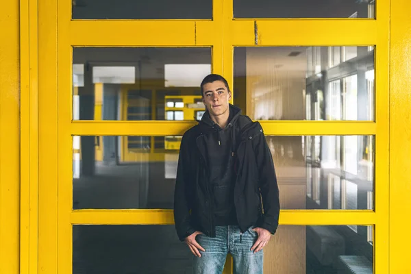 Портрет молодого человека перед желтыми окнами — стоковое фото
