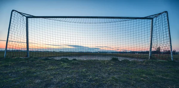 Gol de futebol no por do sol com céu azul e prado — Fotografia de Stock