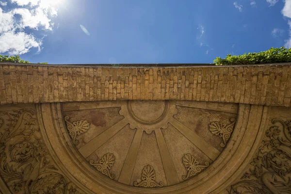 Antiguo arco con decoraciones y cielo azul — Foto de Stock