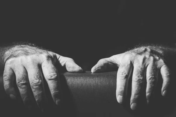 Close-up of two hands holding on to something, in black and white — Stock Photo, Image