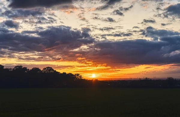 Beautiful sunset over a meadow with dramatic sky — Stock Photo, Image