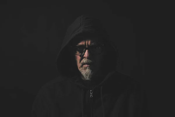 灰色の髭とパーカーと眼鏡を持つ男の暗い肖像画 — ストック写真