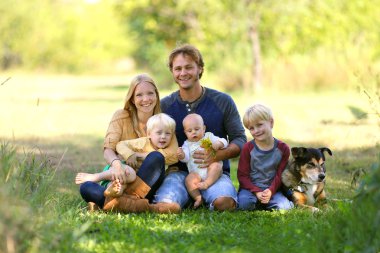 Mutlu aile 5 kişi ve köpek güneşli bahçe içinde