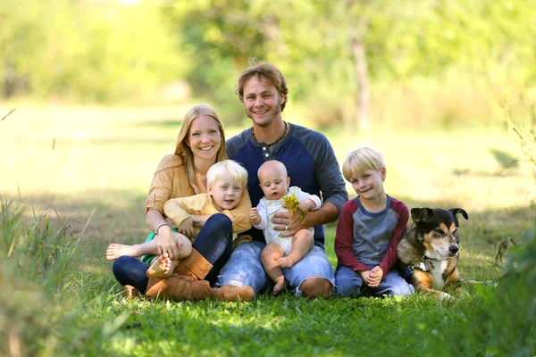 Glad familj av 5 personer och hund i soliga trädgård — Stockfoto