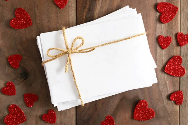 Pilha de Envelopes amarrado com arco de fio cercado pela forma do coração — Fotografia de Stock