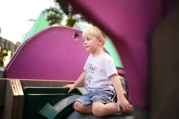 Bonito criança brincando sozinho no parque infantil — Fotografia de Stock