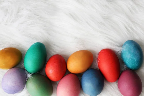 Oeufs de Pâques peints colorés encadrant fond blanc moelleux — Photo