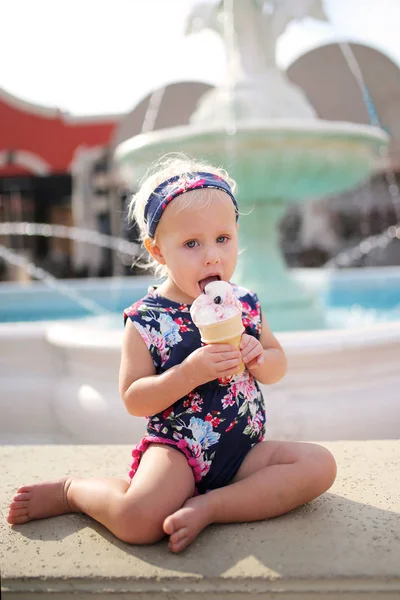 Mignon, à la mode Un an bébé fille manger de la crème glacée cône O — Photo