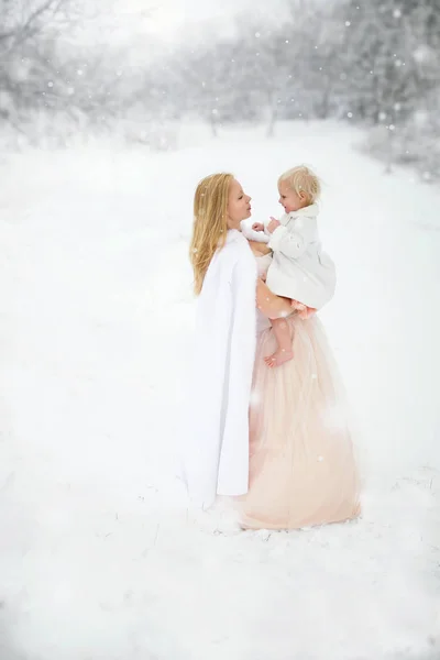 Moeder en dochter gelukkig knuffelen in de sneeuwstorm — Stockfoto