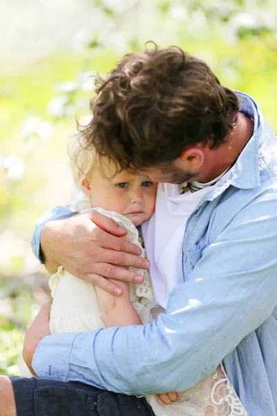 Отец держит и утешает плачущую дочь ребенка — стоковое фото