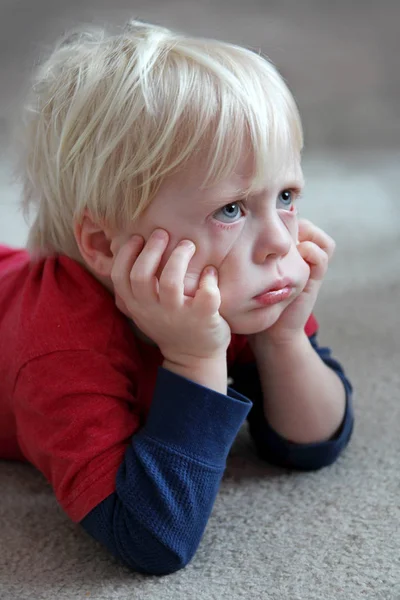 Divertido niño pequeño que mira gruñón o puchero — Foto de Stock