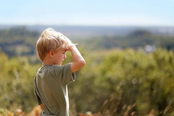 Liten pojke utanför på vandra tittar ut över träden på Bluff — Stockfoto