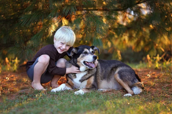 Milý chlapeček objímání psem Pet německý ovčák Mix mimo — Stock fotografie