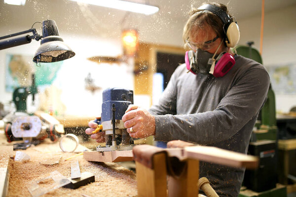 Wood Worker Building Guitar in his Shop, Using a Plunge Router T
