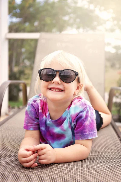 Linda niña feliz niño sonriendo como ella yace fuera de la piscina , —  Fotos de Stock