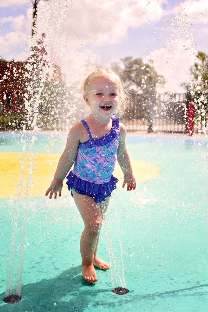 Cute Baby Toddler Girl Playing Outside in Water at Splash Park