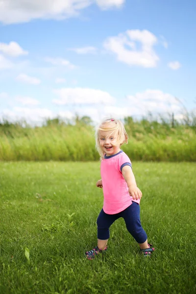 Mignon bébé tout-petit fille runing dehors dans l 'herbe sur un été d — Photo