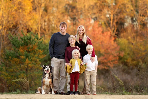 Glückliche junge Familie mit Eltern und Kindern und Hund draußen — Stockfoto