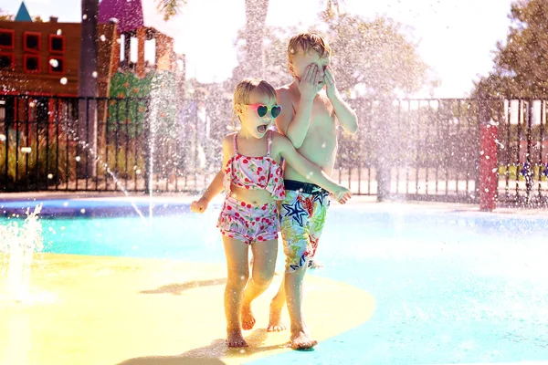 Dos niños pequeños jugando afuera en el parque de salpicaduras de agua — Foto de Stock