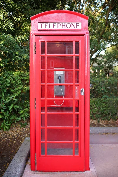 昔ながらの英国スタイルの赤い塗装電話ボックスが歩道に座っています — ストック写真