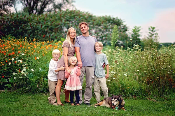 一个快乐而健康的白人家庭 带着三个小孩和一只狗 微笑着在花园外拍照 — 图库照片