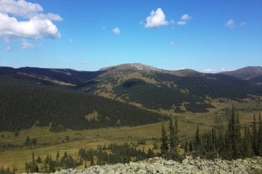 Mavi gökyüzünün altındaki dağlık arazide Ergaki doğa parkı