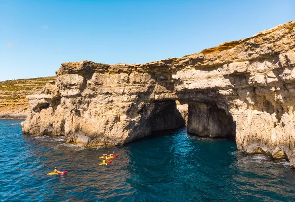 Bir grup kanocu mağaranın altında. Comino Adası. İnsansız hava aracı manzarası. Avrupa. Malta ülkesi