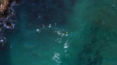 Sörf tahtasındaki sörfçülerin havadan görünüşü. Ghajn Tuffieha plajı. Malta 