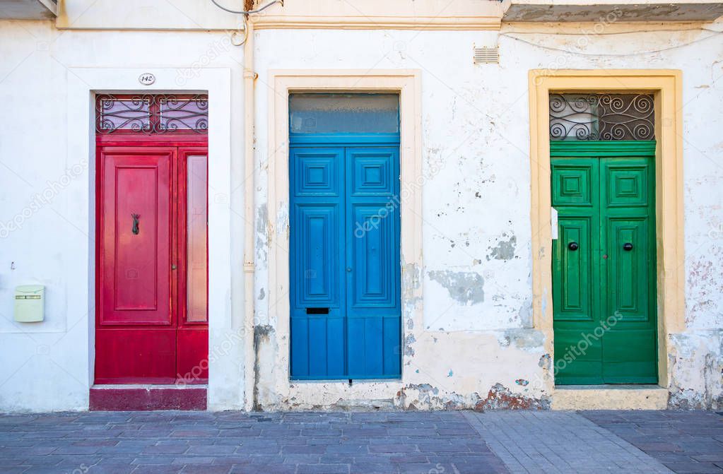Three typical maltese doors in Marsaxlokk village. Red, blue, green doors. Malta