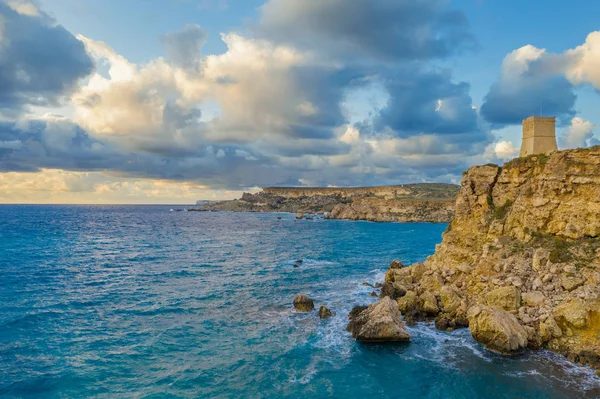 Ghajn Tuffieha Kulesi 'nin havadan görüntüsü. Deniz, gün batımı, bulutlu mavi gökyüzü. Manzara. Malta 