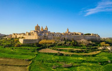 Mdina şehri - Malta 'nın eski başkenti. Havadan doğa manzarası, güneşli bir gün, mavi sinsi kış, bir sürü yeşil çimen, tarla. Malta 