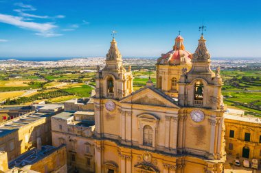 Mdina şehrinin ana kilise ve meydanı - eski Malta başkenti. Havadan doğa manzarası, güneşli bir gün, mavi sinsi kış, arka planda bir sürü yeşil çimen. Malta adası