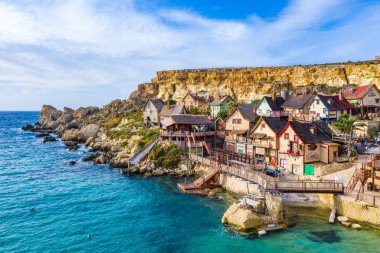 Aerial view of tourist attraction Popeye village, also known as Sweethaven village. Sunny day, blue sea. Mellieha city. Malta 