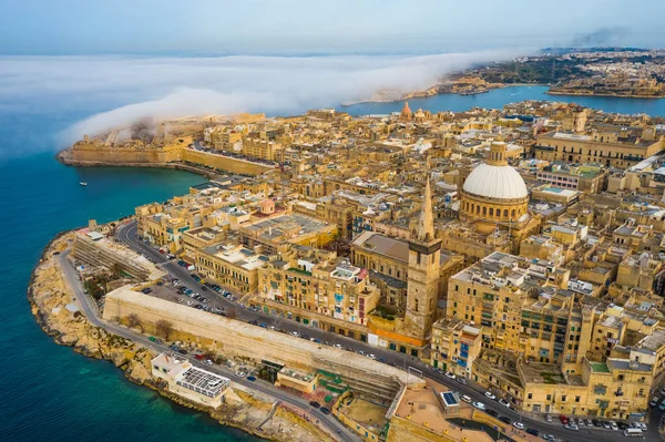 Valletta 'nın, kubbenin, kilisenin havadan görünüşü. Bulutlar, mavi gökyüzünde sis. Malta ülkesi