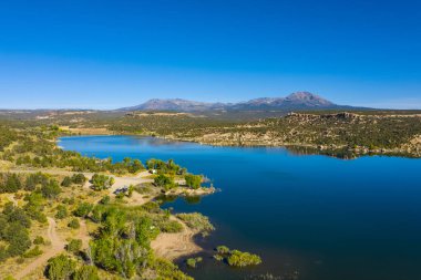 Amerikan tabiatının havadan görünüşü. Mavi gökyüzü ve göl, dağların suda yansıması. ABD 'nin Utah eyaletindeki rezervuarı ele geçirin.
