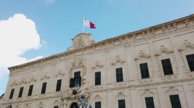 Malta 'nın Valletta şehrindeki Castille Sarayı' ndaki bayrağı. Malta adasının başkenti. Mavi gökyüzü ve bulutlar