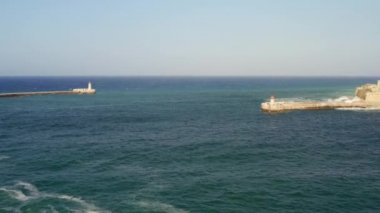 Büyük limanın havadan görüntüsü - Malta adasının ana limanı. Kırmızı deniz feneri, Ricasoli Kalesi. Akdeniz 'de büyük dalgalar.