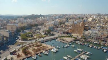 Msida marinası, kilise, yatlar, tekneler. Güneşli bir gün. Kamera ileri gidiyor. Malta adası