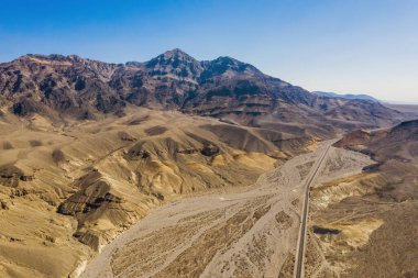Ölüm Vadisi ulusal parkındaki dağların ve karayolunun havadan görüntüsü.