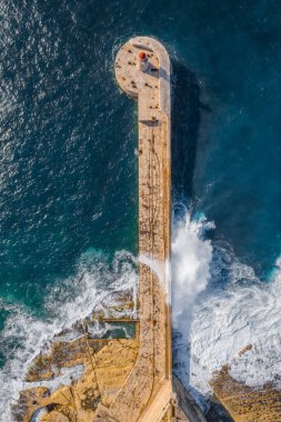 Kızıl deniz fenerinin havadan görünüşü, büyük fırtınalı dalgalar, Akdeniz. Malta ülkesinin büyük limanı