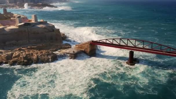 暴雨天气下 红色防波堤桥上大浪的空中景观 靠近点 相机向后移动马耳他岛瓦莱塔市 — 图库视频影像