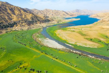 Eğlence Alanının havadan görünüşü. Yeşil renkli çimenler, mavi gökyüzü, sarı dağlar, sabah, mavi su. Sonbahar manzarası. Kaliforniya, ABD